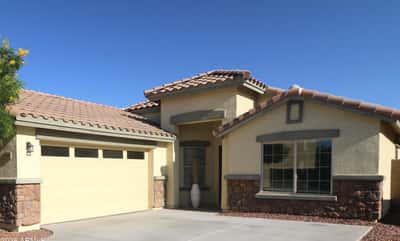 The charming covered entry and stone-accented exterior create a warm welcome while the spacious driveway and attached garage add everyday convenience to this beautifully maintained Buckeye property.