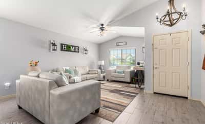 Bright windows, vaulted ceilings, updated flooring, and tasteful finishes make this inviting living room an ideal space for relaxing while enjoying the home's open-concept design.