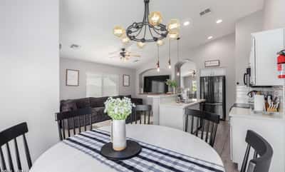 The open dining area overlooks the modern kitchen and spacious family room, creating an ideal layout for entertaining. Updated lighting, soaring ceilings, and contemporary finishes enhance the home's appeal.