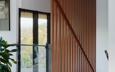 This stunning entryway features modern wood accents and sleek glass details, creating an inviting atmosphere.