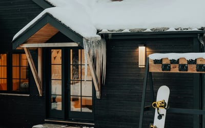Cozy mountain retreat with ski-in access, featuring a snow-covered exterior and inviting entryway.