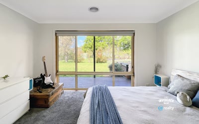Bright bedroom featuring a large window with garden views, complemented by modern furnishings and cozy atmosphere.