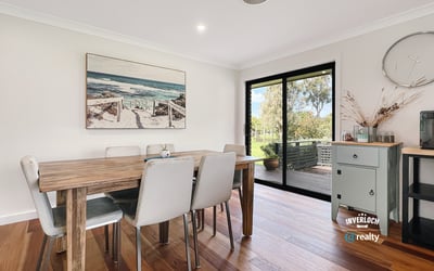 Bright dining area featuring large windows, showcasing views of the outdoors and modern design elements.