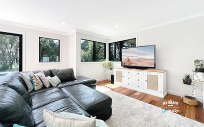 Spacious living area features large windows, modern furnishings, and ample natural light for a welcoming atmosphere.