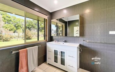 Bright and airy bathroom featuring modern fixtures, ample natural light, and scenic garden views.