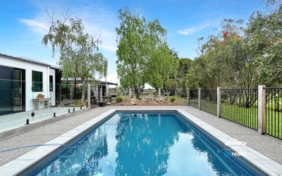This property features a refreshing pool and landscaped yard, perfect for outdoor gatherings and relaxation.