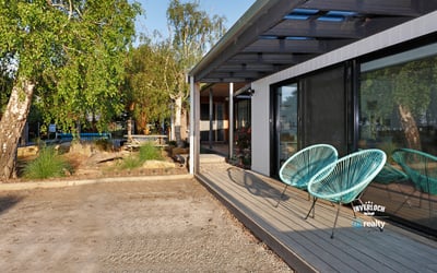 Discover this contemporary home featuring inviting outdoor seating and a spacious yard, perfect for entertaining.