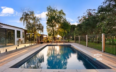 Discover this inviting outdoor space featuring a refreshing pool, surrounded by lush greenery and modern amenities.