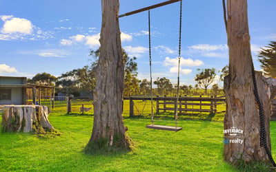 Expansive property featuring a relaxing swing, surrounded by lush greenery and open countryside views.