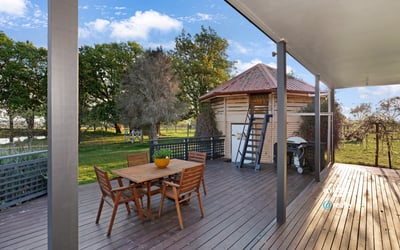 Spacious outdoor deck with direct access to lush greenery, ideal for entertaining and relaxation.