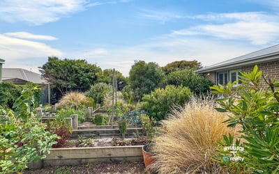 Lush, well-maintained garden beds invite gardening enthusiasts to cultivate their dreams in this vibrant outdoor space.