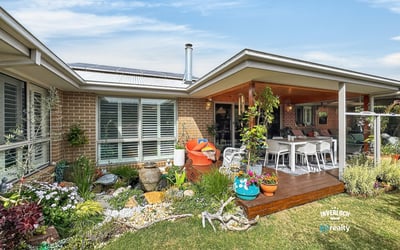 Inviting outdoor space featuring lush gardens and a spacious entertaining area, perfect for gatherings or relaxation.