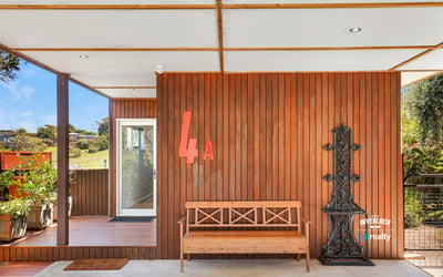 Modern entrance featuring a unique wooden design, inviting natural light and showcasing outdoor views.