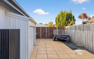 Spacious outdoor area featuring paved parking, perfect for vehicles or recreational equipment, with secure fencing.