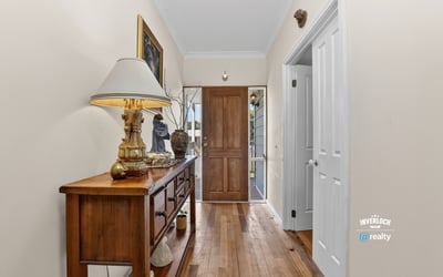 Bright and inviting entryway featuring warm hardwood floors and a view of the welcoming front door.