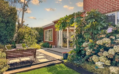 Discover this inviting outdoor space, featuring lush landscaping and a cozy seating area for relaxation.