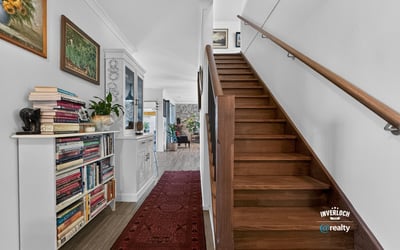 Spacious entryway featuring a wooden staircase, built-in shelving, and vibrant decor create a welcoming atmosphere.