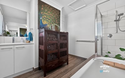 Contemporary bathroom featuring modern fixtures, natural light, and a unique wooden cabinet for added storage.
