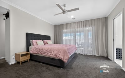 Spacious bedroom featuring a large bed, natural light from expansive windows, and contemporary design elements.