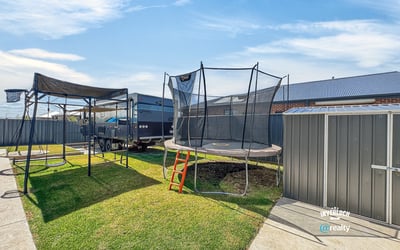 Spacious backyard featuring a trampoline, perfect for outdoor fun and family gatherings, with ample storage options.