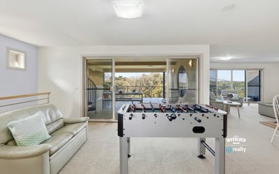Spacious recreational area with a foosball table and large windows showcasing captivating outdoor views.