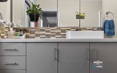 Modern bathroom featuring sleek cabinetry, contemporary fixtures, and a unique mosaic tile backsplash.