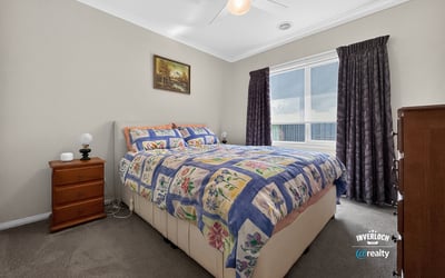 Bright bedroom featuring a spacious layout, large window for natural light, and cozy furnishings.