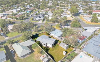 Spacious lot with potential, featuring a cozy home and scenic views near waterfront amenities.