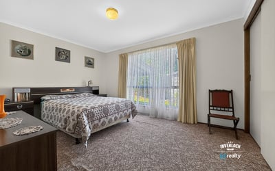 Spacious bedroom featuring large windows that invite natural light and offer a view of the garden.