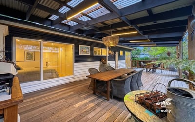 Spacious outdoor deck with ample seating, perfect for relaxed gatherings and enjoying the surrounding greenery.