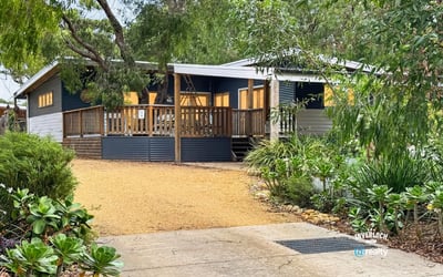 Bright, inviting home set on a spacious lot with a welcoming deck and lush landscaping.