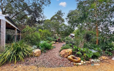 This landscaped garden features diverse plantings and unique stone accents, creating a vibrant outdoor oasis.
