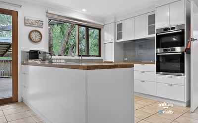 Modern kitchen featuring high-end appliances, ample storage, and large windows for natural light. Perfect for cooking enthusiasts.