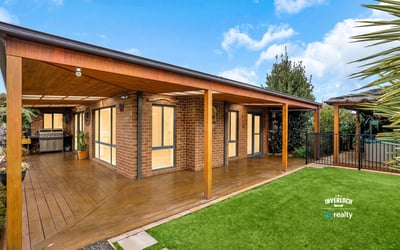 Modern outdoor living area featuring wooden decking, perfect for entertaining in a scenic, landscaped environment.