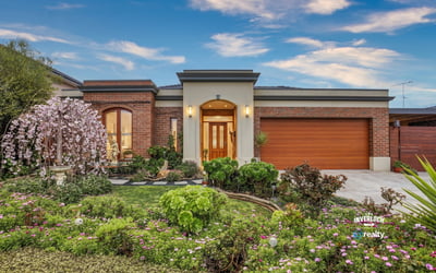 This inviting home features vibrant landscaping, a spacious garage, and a welcoming entryway.