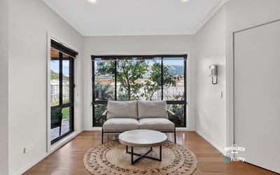 Bright and inviting living space featuring large windows that offer a view of the lush garden.
