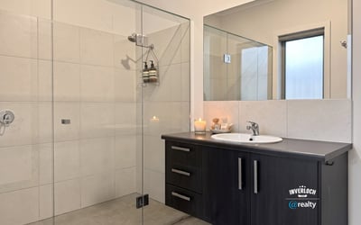 Modern bathroom featuring a spacious shower, sleek cabinetry, and natural light for a refreshing ambiance.