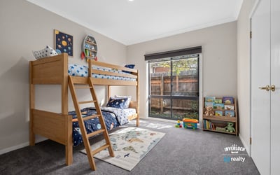 Bright, inviting kids' bedroom featuring a lofted bed and spacious play area with natural light.