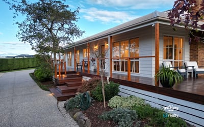 This inviting home features a spacious porch, landscaped gardens, and ample natural light throughout.