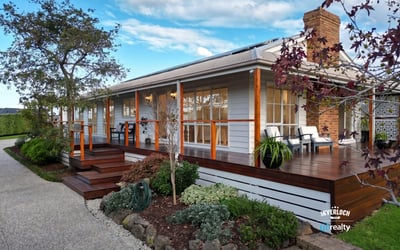Inviting home features a spacious deck, landscaped garden, and picturesque setting, perfect for outdoor living.
