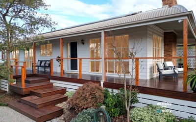 Discover a beautifully designed home featuring a welcoming porch and well-maintained landscaping, perfect for outdoor enjoyment.