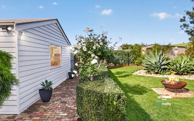 Discover a well-maintained outdoor space featuring lush greenery and a cozy fire pit for gatherings.