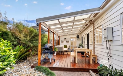 Spacious covered patio with ample seating and outdoor grilling area, perfect for entertaining and relaxing.