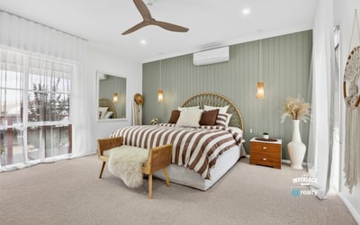Bright and spacious bedroom featuring neutral tones, a comfortable bed, and inviting decor for relaxation.