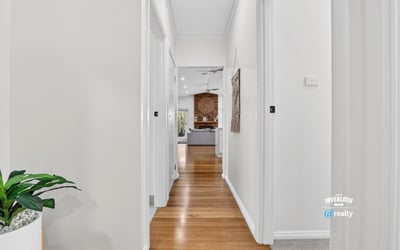 Bright, inviting hallway leading to a spacious living area, showcasing modern design and warmth throughout.