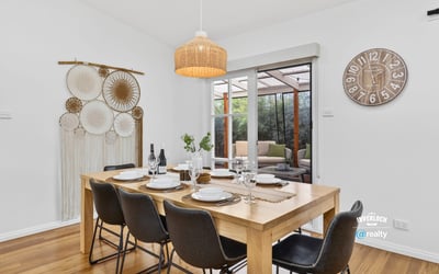 Bright dining area features a spacious table, inviting decor, and views of a cozy outdoor space.