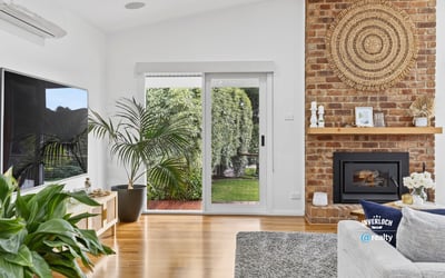 Bright living space featuring a cozy fireplace, modern amenities, and seamless indoor-outdoor access.