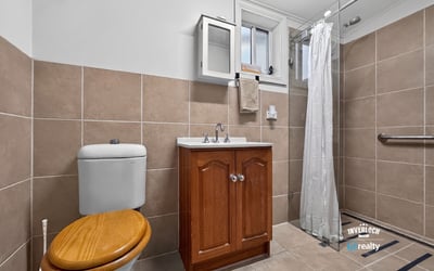 Modern bathroom featuring a sleek shower and functional design with ample storage options.