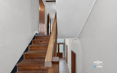 Bright and spacious staircase leading to additional living areas, featuring hardwood accents and natural light.