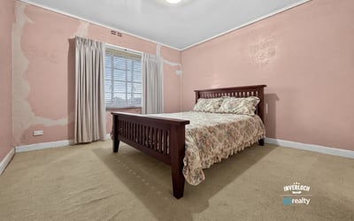 Spacious bedroom featuring natural light, ample storage, and unique wall textures ready for personalization.